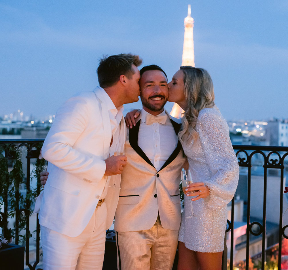 Bride and groom kissing their wedding planner