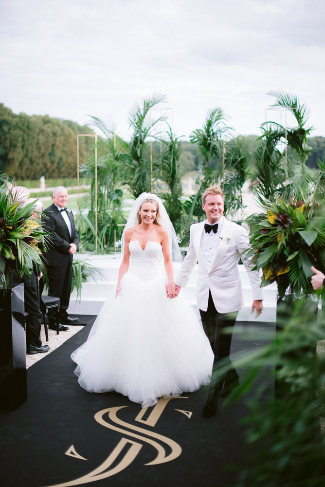 Bride and groom walk hand in hand on the day of their destination wedding in France